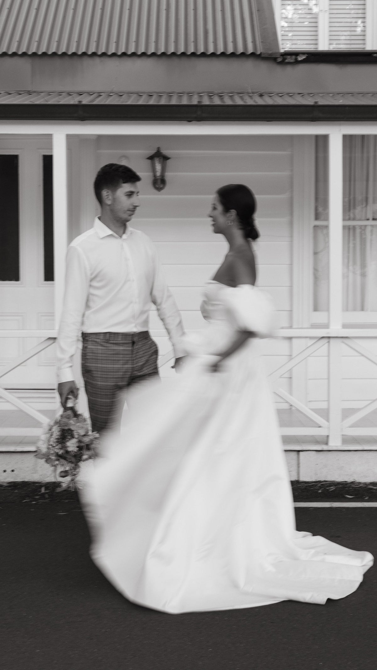 Couple outside a white villa, bride turning in a satin wedding dress with puff sleeves and sweeping skirt, The Dark Side of The Moon