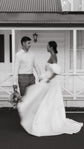 Couple outside a white villa, bride turning in a satin wedding dress with puff sleeves and sweeping skirt, The Dark Side of The Moon