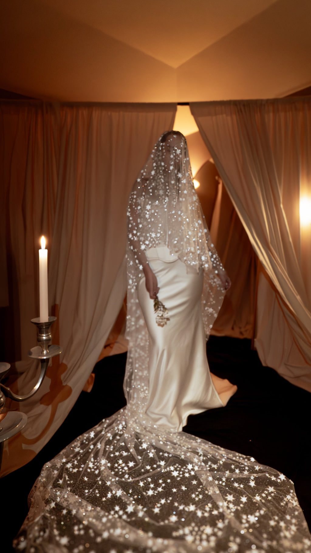 Cathedral wedding veil with a blusher over the face, scattered silver stars across the tulle train, candlelit drapes, Velum Veil by Ephemeris