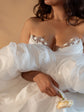 Crop of a satin bridal corset with star appliques at the neckline, bride hugging voluminous puff sleeves and a rose, Venus Corset