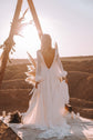 Back view of an open-back chiffon sample wedding dress under a triangle arch at sunset, candles on a rug, When the Moon is Out Sample