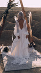 Back view of an A-line chiffon sample wedding dress with long sleeves and a deep open back under a wooden arch, When the Moon is Out Sample