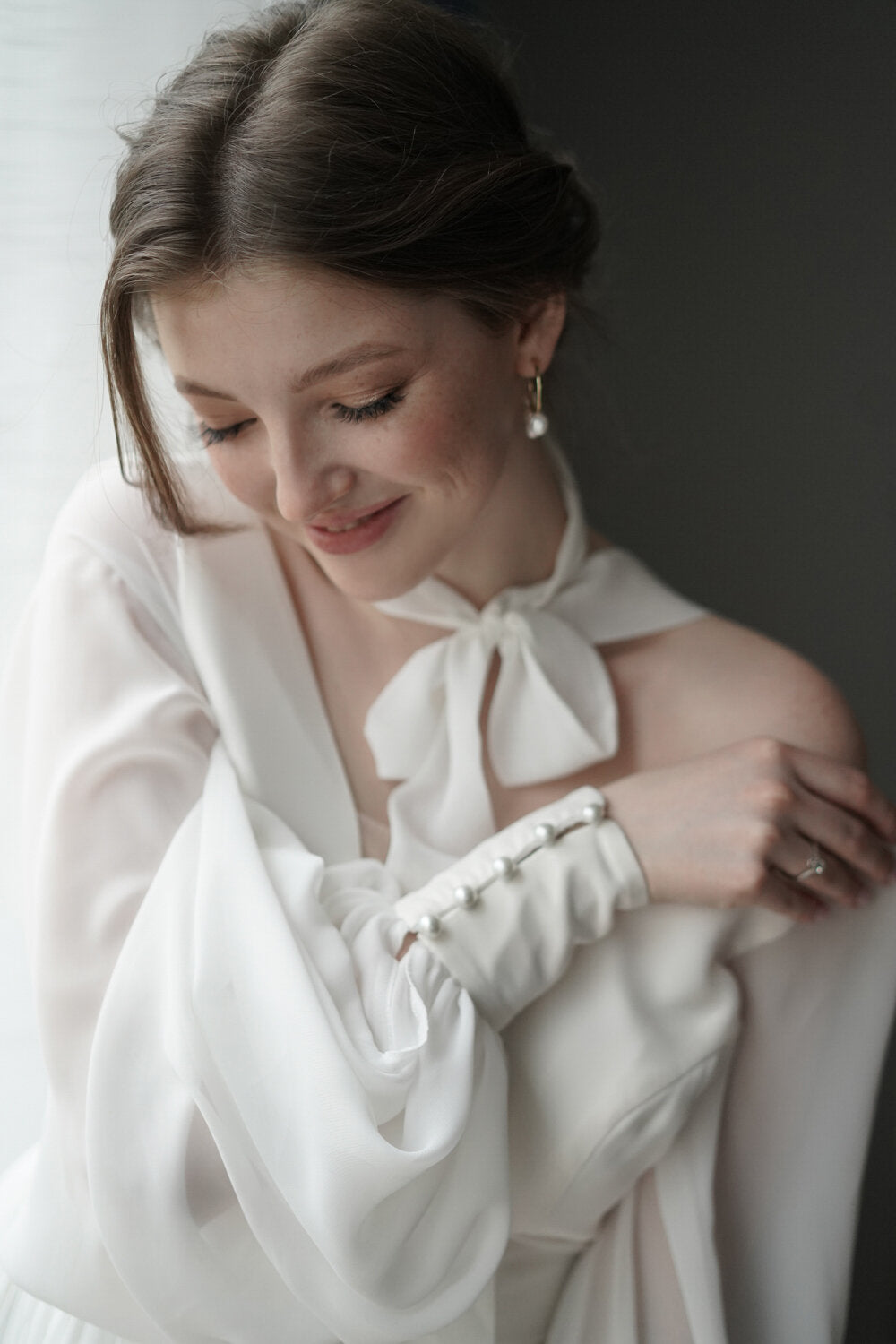 Smiling bride with the scarf tied in a bow at her neck, chiffon sample wedding dress sleeve with a pearl-buttoned cuff, When the Moon is Out Sample