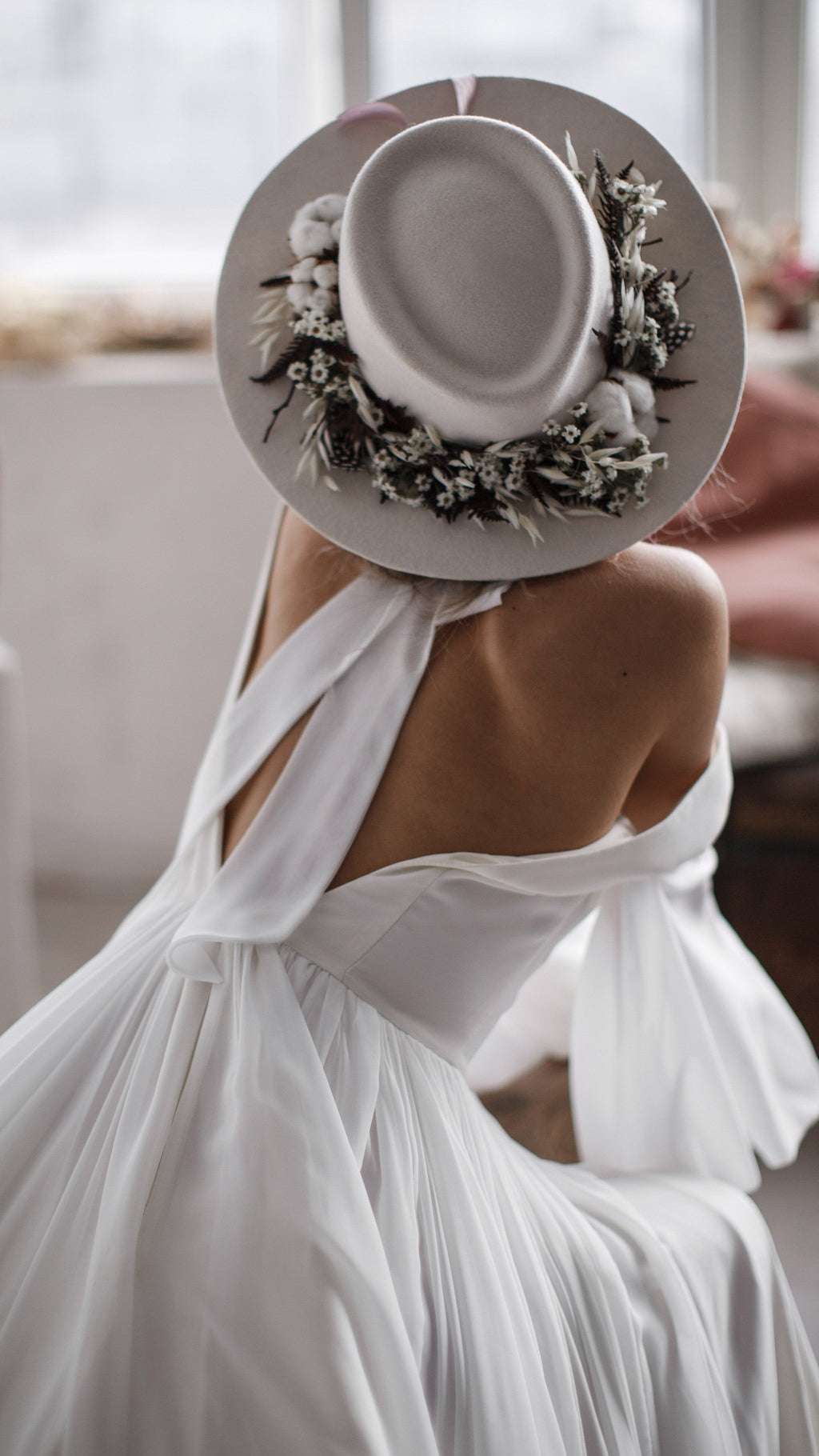 From above, a seated bride in a hat, chiffon wedding dress pooled around her and the back scarf crossed over the V, When the Moon is Out