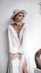 Bride in a hat with a chiffon tie at the neck, plunging V neckline wedding dress with balloon sleeves and a slit, When the Moon is Out