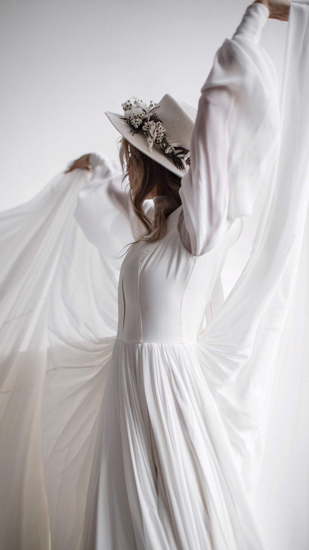 Bride lifting sheer chiffon high behind her in a long-sleeve wedding dress, the fabric fanning like wings, editorial, When the Moon is Out