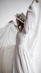Bride lifting sheer chiffon high behind her in a long-sleeve wedding dress, the fabric fanning like wings, editorial, When the Moon is Out