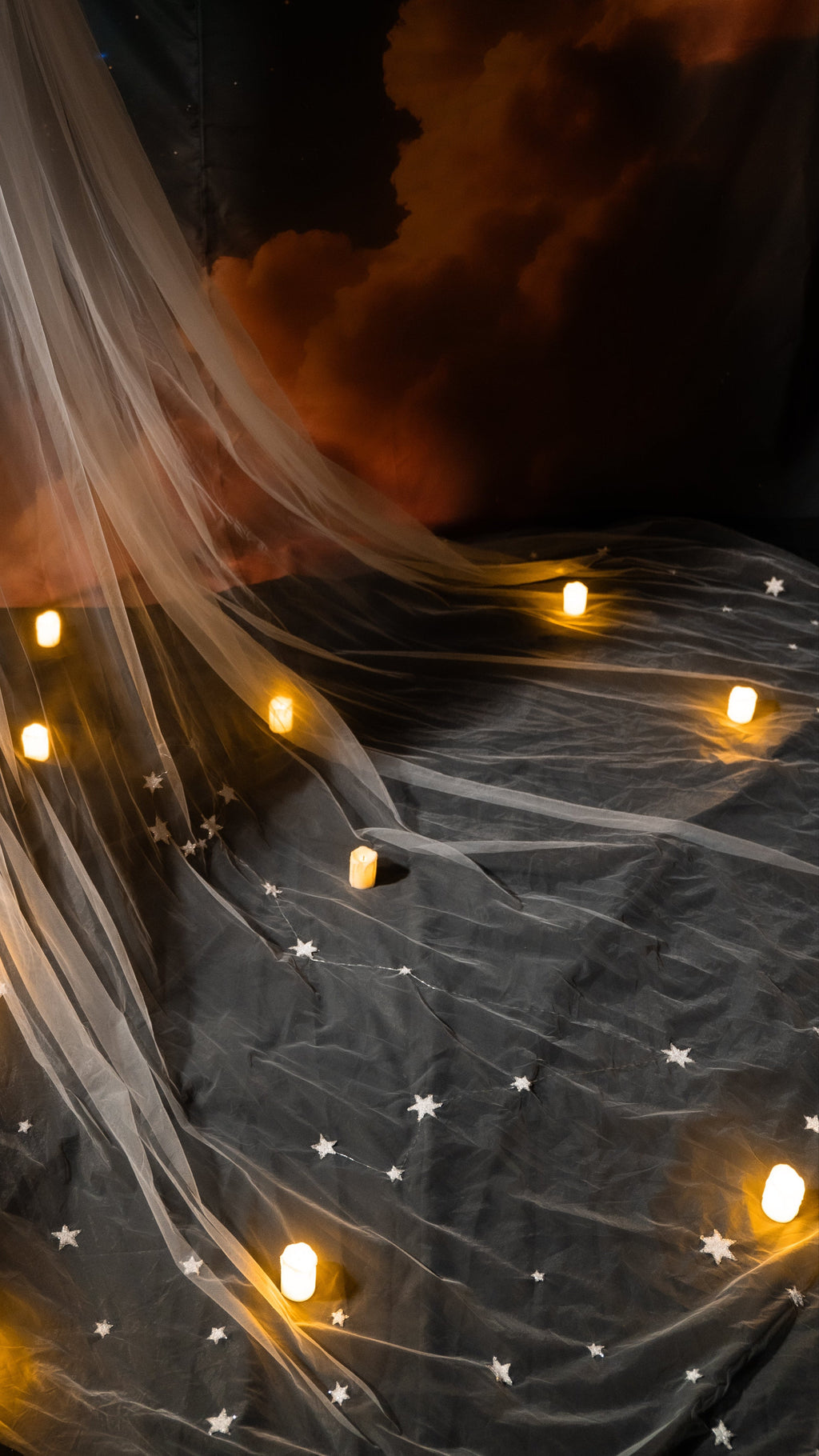 Close view of hand-placed stars forming constellations across the tulle of a wedding veil, candles glowing on the train, Zodiac Veil