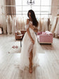 Mirror selfie in a bridal salon, model in an off-shoulder tulle sample wedding dress with a front slit, barefoot on wood floor, Whisper Sample