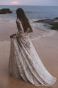 Bride walking toward the sea at sunset, low open back and flowing skirt of an ivory glitter lace wedding dress, Galaxy Ivory