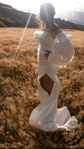 Back view of statement detachable sleeves on a bride in a slit crepe gown with train, sun flare over the hills, My Darling Hurricane Sleeves